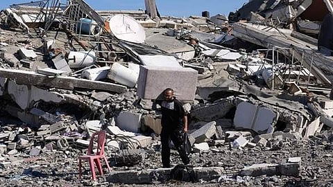 ഇസ്രയേൽ ആക്രമണത്തിൽ തകർന്ന വീടിനരികെ പലസ്തീൻകാരൻ