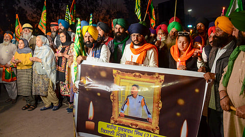 മരിച്ച കർഷകന്റെ ചിത്രവുമായി കർഷകർ പ്രതിഷേധിക്കുന്നു