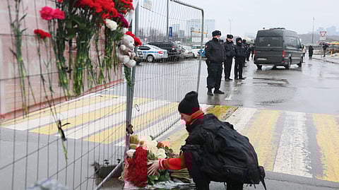 ആക്രമണം നടന്ന ക്രോക്കസ് സിറ്റി ഹാളിന് പുറത്തുള്ള താല്ക്കാലിക സ്മാരകത്തില് പൂക്കള് അര്പ്പിക്കുന്ന സ്ത്രീ