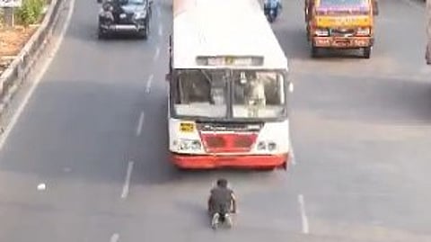dangerous stunt by suddenly laying on road in front of a running bus