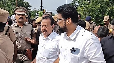 ചെളി വാരിയെറിഞ്ഞതിനെത്തുടര്ന്ന് മന്ത്രിയെ വാഹനത്തില് കയറ്റാന് ശ്രമിക്കുന്ന പൊലീസുകാര്