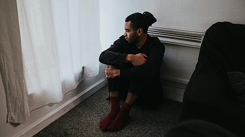 man sitting in a room alone mental stress