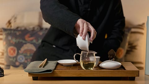 Man pours green tea to cup