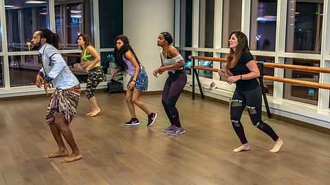 a group of people practicing Zumba in a room