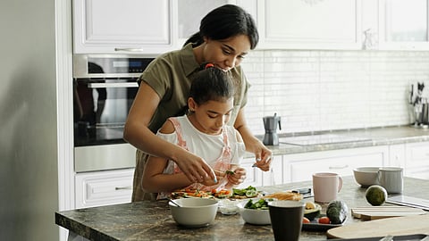 mother helping daughter to cook