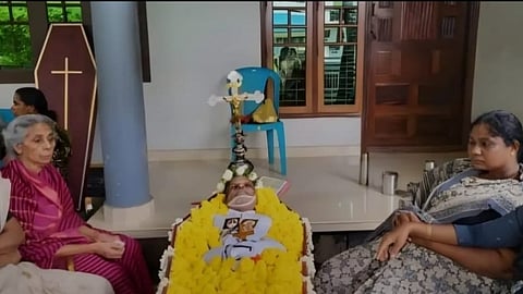 Relatives stand next to Thomas' body, which was laid outside the house.