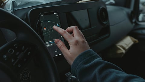 MAN USING GPS NAVIGATOR FOR DRIVING
