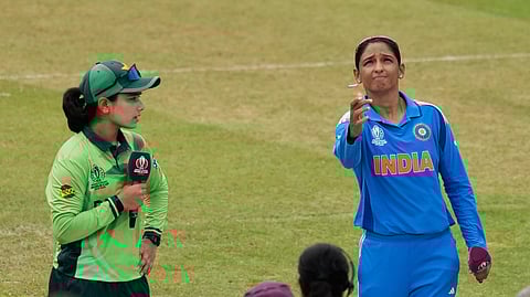 India's captain Harmanpreet Kaur, right, tosses a coin as Pakistan's captain Fatima Sana watches