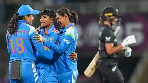 Kranti Gaud, center, celebrates with captain Harmanpreet Kaur, right, and vice captain Smriti Mandhana after taking the wicket