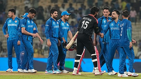 Afghanistan's captain Rashid Khan, second right, shakes hands with Canada's Jaskarandeep Buttar after winning the T20 World Cup cricket match