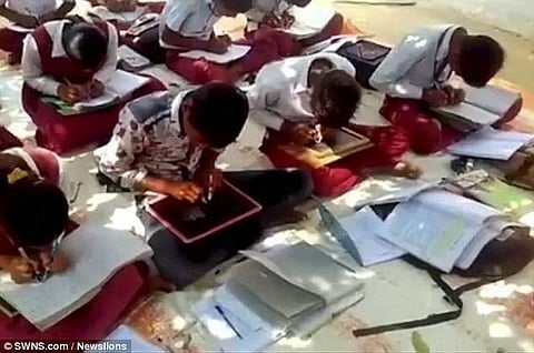 students writing on slate