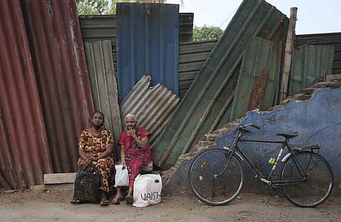 മണ്ണെണ്ണയ്ക്കായി ക്യൂ നിന്നു തളര്ന്നു വഴിയരികില് ഇരിക്കുന്ന ലങ്കന് സ്ത്രീകള്/എപി