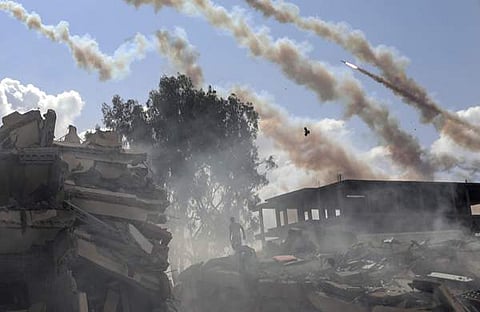 സെൻട്രൽ ഗാസ മുനമ്പിൽ ഇസ്രയേൽ വ്യോമാക്രമണത്തെ തുടർന്ന് തകർന്ന കെട്ടിടങ്ങൾക്ക് മുകളിലൂടെ പറക്കുന്ന റോക്കറ്റുകൾ/ പിടിഐ