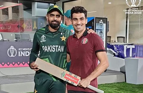 ബാബര് അസം തന്റെ ബാറ്റ് അഫ്ഗാന് താരം ഗുര്ബാസിന് നല്കുന്നു/  എക്സ്