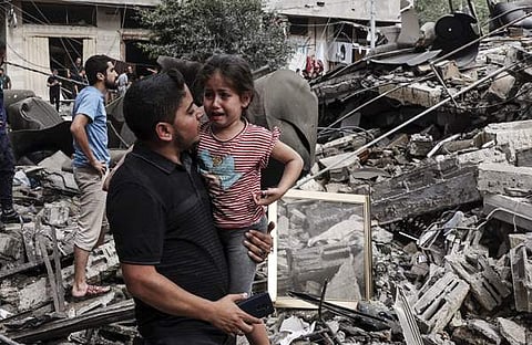 ഇസ്രയേല് ആക്രമണത്തില് നിന്ന് രക്ഷപ്പെട്ട കുട്ടിയുമായി രക്ഷാപ്രവര്ത്തകന്/എഎഫ്പി