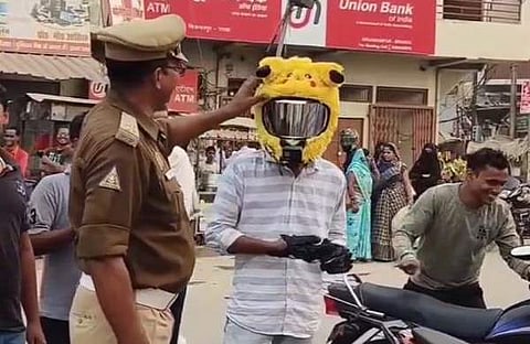 യുവാവിന്റെ ഹെൽമെറ്റ് പൊലീസ് പരിശോധിക്കുന്നു/ എക്സ് വിഡിയോ സ്ക്രീൻഷോട്ട്