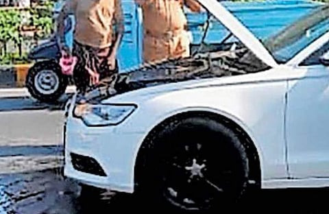 കാറിൽ നിന്ന് ഉയർന്ന തീ അണയ്ക്കാനുള്ള ശ്രമം