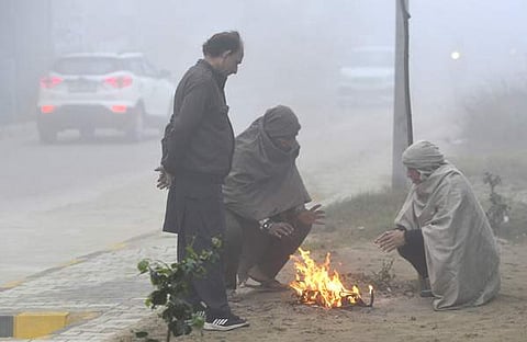 തണുപ്പിൽ നിന്ന് രക്ഷതേടി ആളുകൾ തീ കായുന്നു/ പിടിഐ