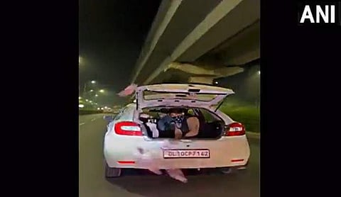 കാറില് നിന്ന് കറന്സി നോട്ടുകള് വലിച്ചെറിയുന്ന യുവാക്കള്