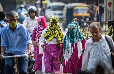 ഷോൾ ഉപയോഗിച്ച് മുഖം മറച്ച് ചൂടിനെ പ്രതിരോധിക്കുന്നു/ എക്സ്പ്രസ് ചിത്രം