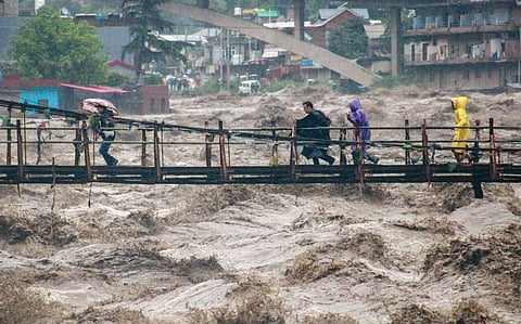കുത്തിയൊലിക്കുന്ന ബിയാസ് നദിക്ക് കുറുകെയുള്ള പാലത്തിലൂടെ മറുകരയിലേക്ക് പോകുന്നവർ/ പിടിഐ