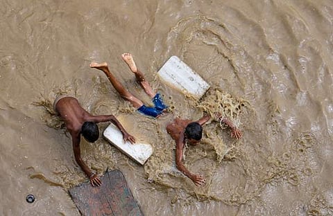 വെള്ളക്കെട്ടിൽ കളിക്കുന്ന കുട്ടികളുടെ ദൃശ്യം, പിടിഐ