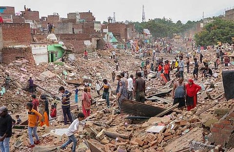 മഥുരയിൽ ഇടിച്ചു നിരത്തിയ വീടുകൾക്ക് മുന്നിൽ താമസക്കാർ/ പിടിഐ