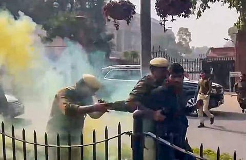 മഞ്ഞകലര്ന്ന പുക പുറന്തള്ളുന്ന ക്യാനുമായി പാര്ലമെന്റ് മന്ദിരത്തിന് പുറത്ത് പ്രതിഷേധിച്ച ഒരാളെ പൊലീസ് പിടികൂടുന്നു/ പിടിഐ, ഫയല്