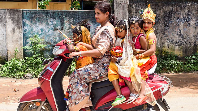 ചിക്കമംഗളൂരുവിൽ കൃഷ്ണൻ്റെയും രാധയുടെയും വേഷം ധരിച്ച കുട്ടികളുമായി ഇരുചക്രവാഹനത്തിൽ സഞ്ചരിക്കുന്ന സ്ത്രീ
