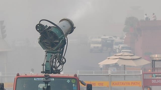An anti-smog gun sprays mist to mitigate smoggy conditions, in New Delh
