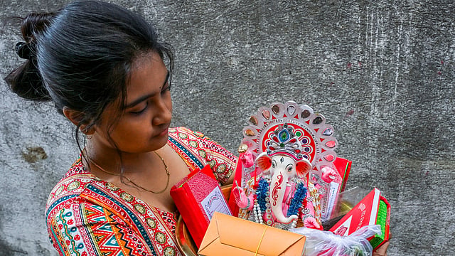 പുതുവത്സര ആഘോഷങ്ങൾക്കിടയിൽ ഗണേശ വിഗ്രഹവുമായി നടക്കുന്ന യുവതി