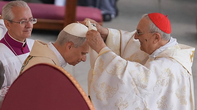 Pope Leo XIV receives the pallium, or lambswool stole, a symbol of the papacy during a Mass for the formal inauguration of Pope Leo XIV's pontificate