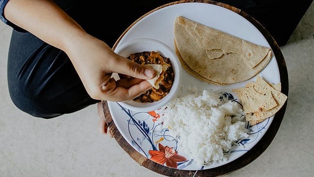 Person Eating Indian food rice and chappati