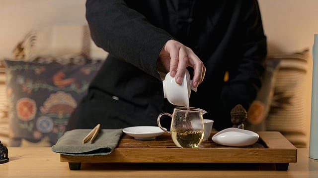 Man pours green tea to cup