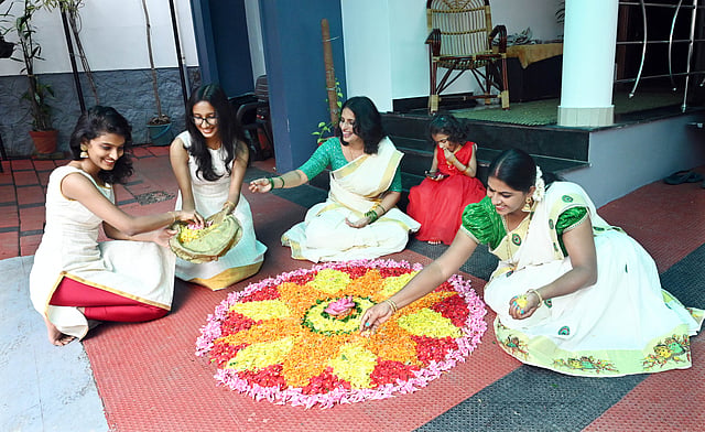 women making pookkalam
