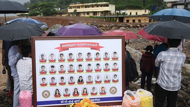 Teachers of Vellarmala GVHSS offering flowers in front of the photos of students who lost their lives during Chooralmala-