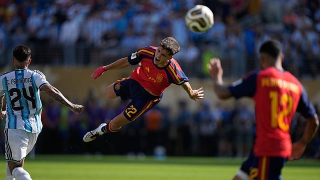 Spain's Pau Cubarsi (22) leaps in the air after he is fouled by Argentina's Enzo Fernandez (24) during the World Cup final soccer match between Spain and Argentina