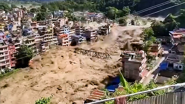 Floodwater flows across a residential area, in Nepal.