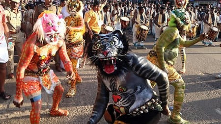 <P>Red, Blue and Black tigers perform at the Pulikkali . Photo by S Lal</P>