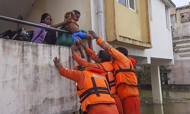 കുഞ്ഞിനെ രക്ഷപ്പെടുത്തുന്ന ദുരന്തനിവരാണ സേന പ്രവര്ത്തകര്/ പിടിഐ