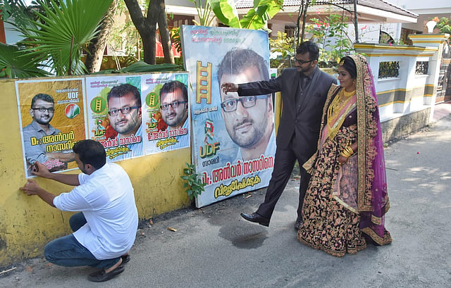 വള്ളക്കടവ് ഡിവിഷനിലെ മുസ്ലിം ലീഗിന്റെ സ്ഥാനാർത്ഥിയായ ഡോ. അൻവർ നാസർ തന്റെ വധുവായ റോഷ്നിക്ക് പ്രചാരണത്തിനായി വീടിന് മുന്നിൽ സ്ഥാപിച്ച പോസ്റ്ററുകൾ കാണിച്ചു കൊടുക്കുന്നു/ ഫോട്ടോ: ബിപി ദീപു/ എക്സ്പ്രസ്