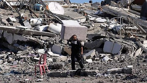 ഇസ്രയേൽ ആക്രമണത്തിൽ തകർന്ന വീടിനരികെ പലസ്തീൻകാരൻ