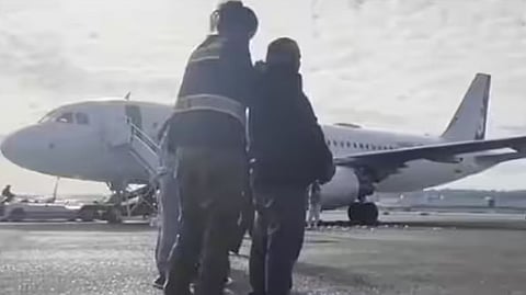 വിമാനത്തില്‍ കയറ്റുന്നതിന് മുമ്പ് ആളുകളെ പരിശോധിച്ച് ചങ്ങലയില്‍ ബന്ധിക്കുന്നു
