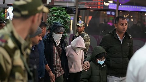 Indian police officials escort immigrants