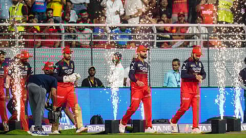 Royal Challengers Bengaluru's players enter the field during the start of the IPL 2025