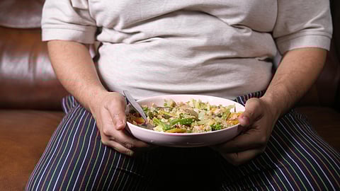 Obese Man eating salad