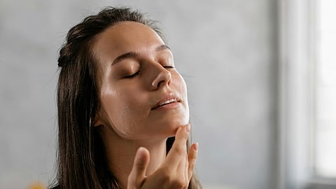 woman applying cream on her face