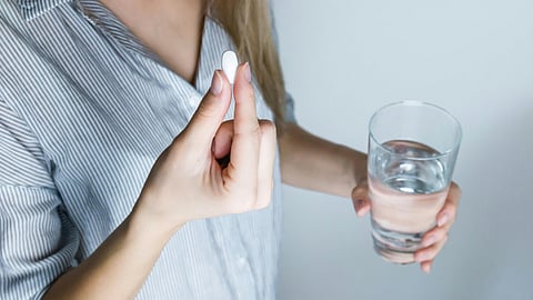 image of woman taking pills