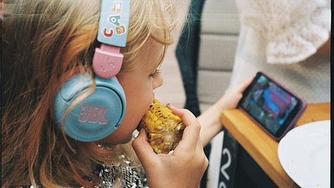 Child eating and watching series in mobile