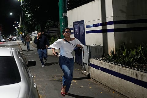 Pedestrians run after explosions and low-flying aircraft were heard in Caracas, Venezuela